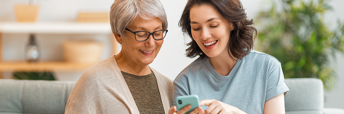 Woman and her mother looking at a smartphone and smiling