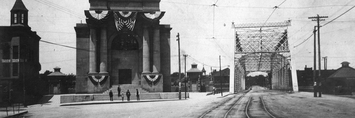 black and white photo of a building and bridge